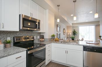 A kitchen with white cabinets and a black stove top oven.